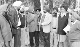 Officials visit a site for constructing a grain market at Ahmedgarh.