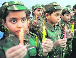 Schoolchildren dressed as Army soldiers hold lit candles as they pay tributes to the victims of the 2001 Parliament House attack, in Amritsar on Saturday.