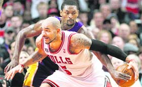 Chicago Bulls' Carlos Boozer (5) and Los Angeles Lakers' Ron Artest battle for control of the ball during the fourth quarter of their NBA basketbal game in Chicago on Saturday.