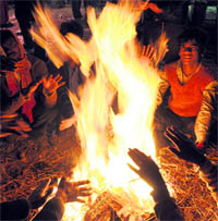 Labourers try to warm themselves on a chilly Sunday evening at Sector 34 in Chandigarh