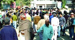 Residents of Mongolpuri gather outside the area police station following blade attacks on three girls, in New Delhi on Sunday.
