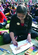 Schoolchildren take part in a painting competition on the theme Save Tiger at the India Gate lawn in New Delhi on Sunday.