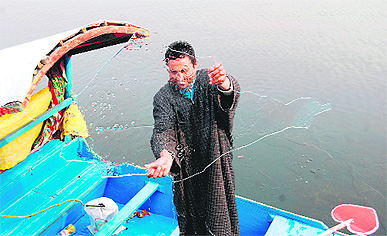 A boatman shows a sheet of ice on the Dal lake in Srinagar on Sunday. 
