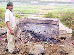 Workers try to take out bitumen from a dump at the railway station in Ahmedgarh. 