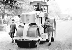 STEAMROLLING INNOCENCE: In complete disregard for the child labour laws, the contractor has engaged minors for the recarpeting of roads. Two children are seen working in Phase VII market, Mohali,