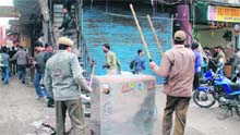 Policemen chase away protesters in Jammu on Monday.