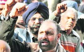 Activists of the Loco Running Staff and Guards Council raise slogans against unjust pay scales at labour office in Ludhiana on Monday.