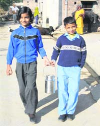 Students at Garnawathi village in Rohtak carry milk to school
