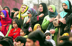 Women beat themselves as they participate in a Muharram procession in Srinagar