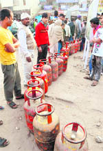 Residents queue up outside a gas agency for LPG refill in Attawa village, Sector 42