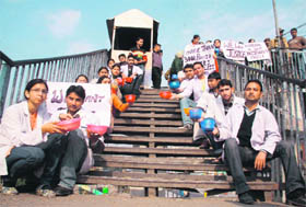 Members of the Jammu and Kashmir Physiotherapy Association stage a protest with begging bowls in Jammu on Thursday