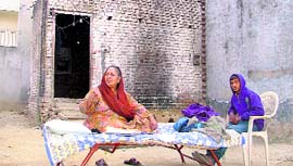 Paramjit Kaur sits on the premises of her house after getting its possession at SBS Nagar in Ludhiana on Thursday.