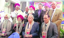 Pensioners being felicitated on the occasion of Pensioners Day in Ludhiana on Friday.