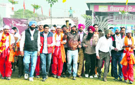 Indian hockey player Sardara Singh carries the Games torch at the Jarkhar stadium in Ludhiana on Friday