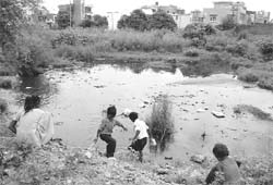 Unwary of the health hazard, children play in the seasonal nullah near Dasmesh Enclave at Dhakoli village.