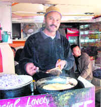 Khursheed, owner of Lovely Omelette Centre, prepares a cheese omelette at his shop.