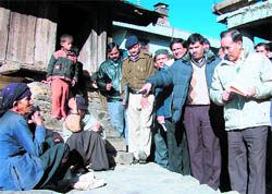 Uttarakhand Chief Secretary Subash Kumar talks to a village woman during his visit 