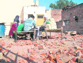 Bricks lying scattered in front of a house which was stoned during a group clash in Gharaunda. 