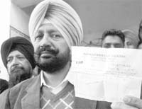 Kharar MLA Balbir Singh Sidhu shows a proof of his being out of station during a press conference in Mohali on Monday.