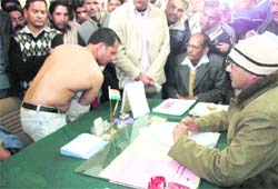 Congress leader Megh Singh Kandari, who was arrested on Sunday, shows his scars allegedly inflicted by the police to SDM of Mussoorie Manoj Kumar on Monday.
