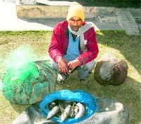 A man with the fish caught illegally from the Rajaji Park near Haridwar on Monday.