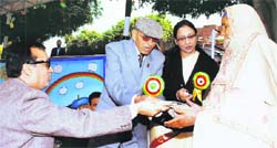 Ajay Maken (left), Union Minister of State for Home, honours a war widow at the annual function of Rising Sun School, near Gharaunda in Karnal.