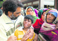 Relatives console Prince, the lone surviving son of deceased Rajesh Kumar and Santosh Rani, at the Ram Bagh cremation ground in Kotkapura