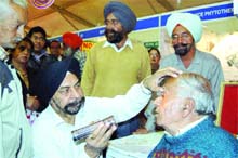 Dr M.S. Basu, an Ayurvedic doctor, checks eyes of a patient at the Arogaya mela in Amritsar. 