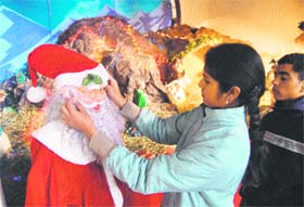 A girl busy decorating Santa Claus at Catholic Church in Shimla on Tuesday