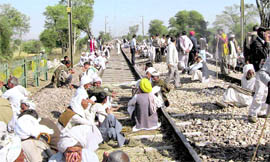 Gujjar protesters sit on a railway track during a dharna at Chokra railway crossing in Bharatpur district of Rajasthan on Tuesday