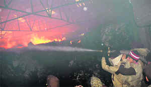 Firemen try to douse the flames at a cotton thread factory in Retgarh village near Samana .