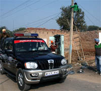 Employees of the Powercom busy in shifting electricity meters out of the houses while cops keep watch in Neor village of Bathinda district on Wednesday