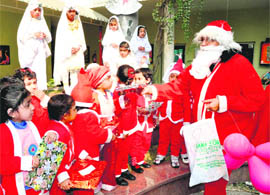 Santa Claus distributes gifts among children ahead of Christmas at The British School, Sector 44, Chandigarh, on Wednesday.