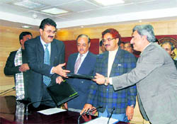 Navneet Sehgal, Principal Secretary (Energy), UP (left), and DV Singh, Director (Technical), Tehri Hydro Development Corporation exchange files of an MoU