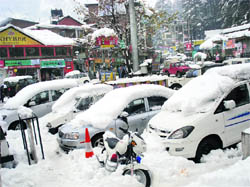 Snow covers roofs of cars in Manali on Friday.