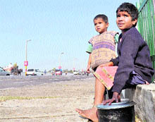 Unaware about the New Year celebrations, poor children guard a container containing meal in Jammu on Friday