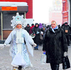 A woman wearing the costume of a Snegurochka (Snow Maiden) (L), walks outside of the Red Square in Moscow, on Friday. New Year is the biggest holiday of the year in Russia, and is followed by the Orthodox Christmas on January 7.