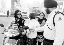 A cop warns a girl violating traffic rules at Zirakpur during the Road Safety Week on Saturday