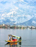 A day after heavy snowfall, a tourist enjoys a shikara ride at the Dal Lake during a sunny day in Srinagar 