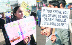 Students carry placards about road safety on the first day of the road safety week in Jammu