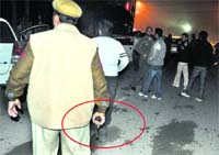A policeman wields a pistol (circled) to drive away rowdy youths on the New Years Eve in Ludhiana.