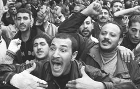 Egyptian Christians vent out their anger as the bodies of victims of a bomb attack are carried into ambulances in front of the Coptic Orthodox church in Alexandria