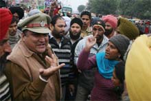 A police official tries to pacify activists of the Valmik Majhabi Sikh Rakhwakaran Bachao Morcha outside the bus stand in Bathinda on Sunday; 