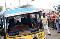 The auto-rickshaw damaged by the transporters. 