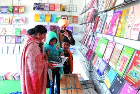 Girl browses through the books under the watchful eyes of her parents at the book fair organised by the National Book Trust (NBT) at the Government Rajindra College in Bathinda. 