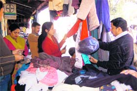 Customers buy woollens at a shop in Dehradun
