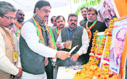 BJP leader Gopinath Munde lights a candle in front of the portrait of Bharat Mata and Dr BR Ambedkar in Haridwar