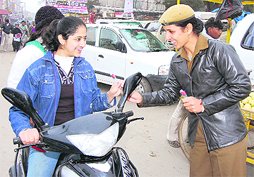 A woman cop gives a rose to an errant scooty rider to convey the message of road safety at Sirsa on Sunday. A Tribune photograph