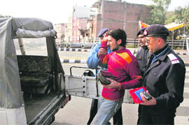 The traffic police apprehends a violator during a special checking in Jammu 