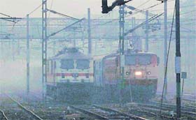 Trains run amid fog at Amritsar railway station on Sunday.